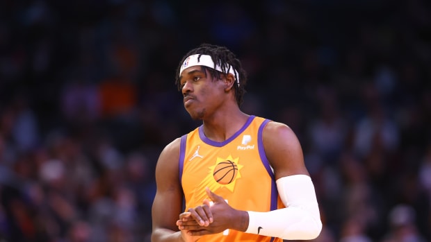 Aaron Holiday standing in Phoenix Suns uniform.